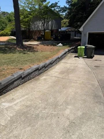 Residential driveway with dark landscape edging bordering mulched planting beds